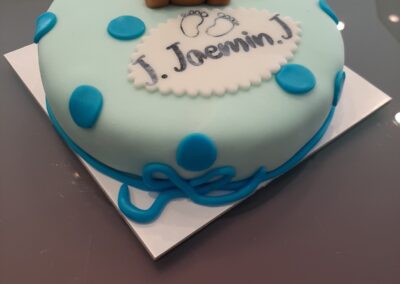 Torta nascita con topper orsetto, decorazioni blu e scritta personalizzata, perfetta per il battesimo o la prima comunione del bambino. Dolci Pensiero Pasticceria autentico e artigianale.