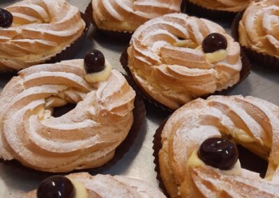 Doppio strato di pasta sfoglia con crema e decorati con ciliegie candite, zucchero a velo e una decorazione di cioccolato bianco, creano un dolce irresistibile e raffinato. Perfetti per ogni occasione speciale.