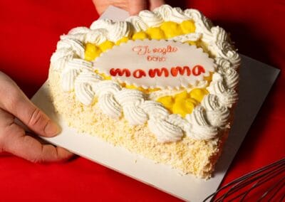 Dolce Pensier torta cuore di crema e cioccolato decorata con panna e frutta candita, perfetta per festeggiare la festa della mamma. Gustosa e ricca, ideale per occasioni speciali e momenti di dolcezza in famiglia.