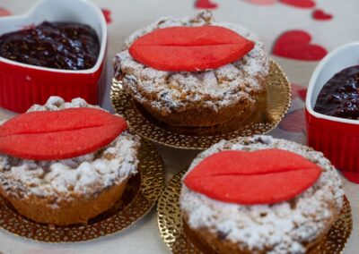 Panettone con decorazione di cuori di pasta di zucchero e confettura di frutta, dolce tipico natalizio, decorato con zucchero a velo e cuore rosso, ideale per occasioni romantiche o festività, disponibili da Dolce Pensier.