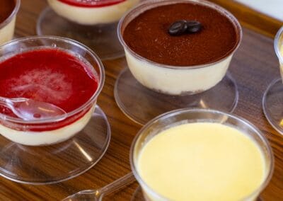 Dolce Pensier: assortimento di dessert al cucchiaio con crema, frutti di bosco e cioccolato, presentati in eleganti coppe di vetro su un tavolo in legno. Perfetti per ogni occasione di dolcezza e relax.