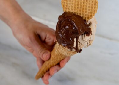 Gelato artigianale con cioccolato fondente, vaniglia e biscotto waffle, servito in cono di cialda croccante. Dolce pensiero per gli amanti dei dessert golosi e raffinati.