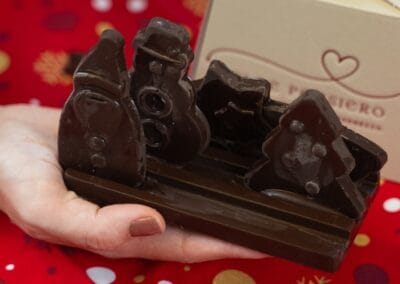 Cioccolato fondente a forma di trenino, perfetto come dolce natalizio, con superficie lucida e dettagli realistici. Ideale come regalo o goloso asporto durante le festività. Artigianale e di alta qualità, da Dolcepensier.