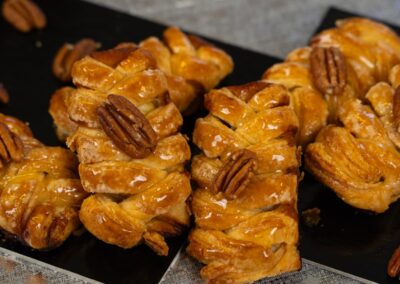 Croissant con noci e miele, dolce artigianale, perfetto per la colazione o la merenda. Decorato con mezzo noce per un tocco di eleganza e sapore irresistibile.